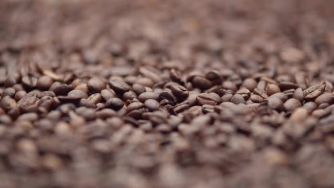 改变对烘焙棕色咖啡豆的关注，宏观拍摄。一大堆咖啡豆，特写。生产具有咖啡因含量的成分的概念，以激发能量