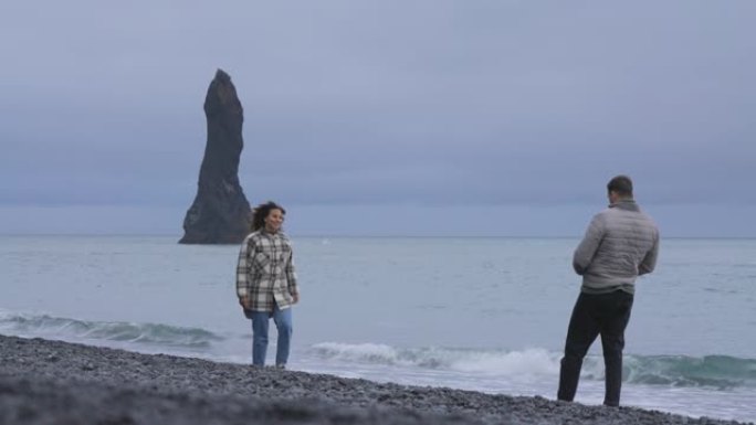 夫妇在冰岛雷尼斯法拉黑沙滩上捕捉快照