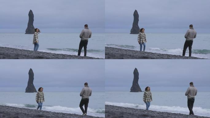夫妇在冰岛雷尼斯法拉黑沙滩上捕捉快照