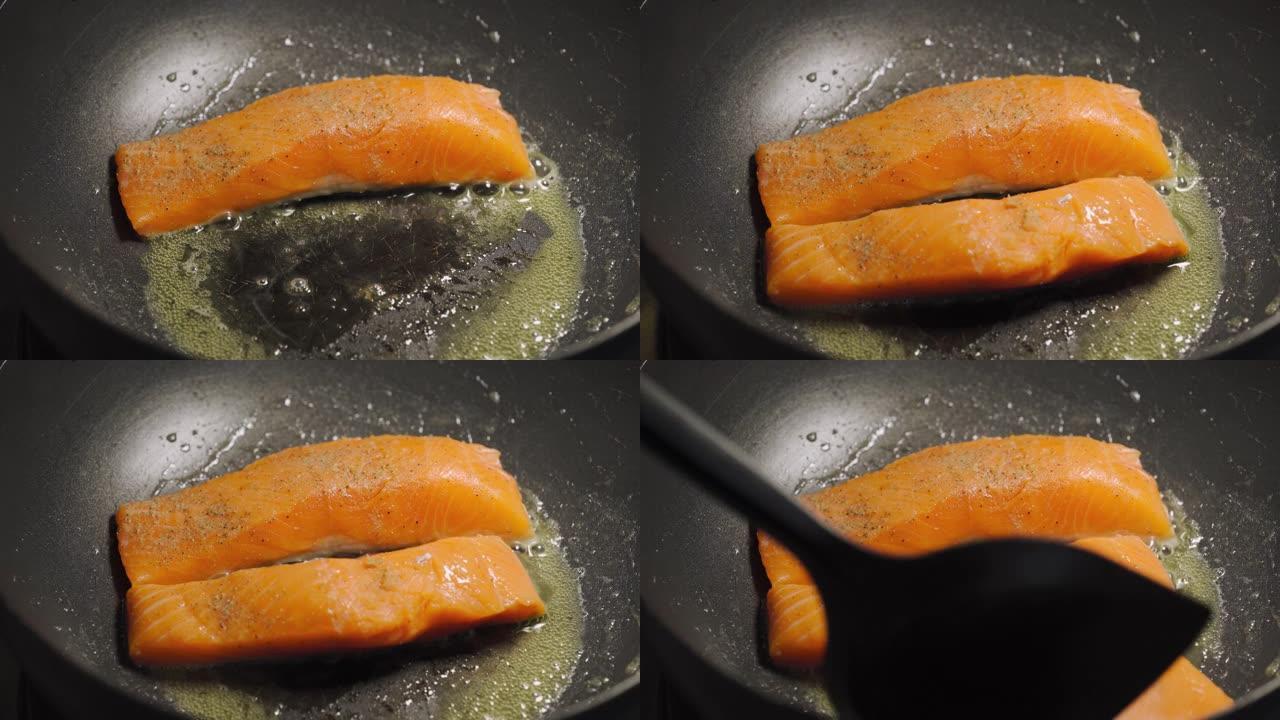 有人把黄油炒三文鱼放在黑锅上。低卡路里的健康菜单。