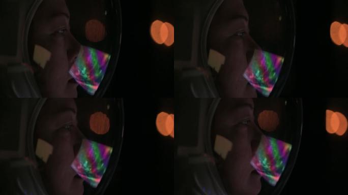 亚洲中国中年女宇航员通过太空飞船的监视器屏幕看着地球