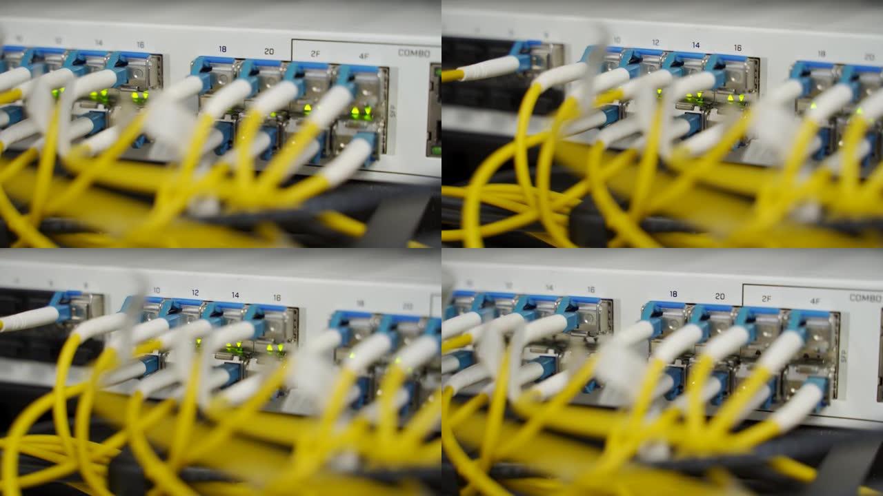 数据中心机房的光服务器和路由器。网络设备闪烁，机架上有灯。连接到端口的光纤线。高速互联网