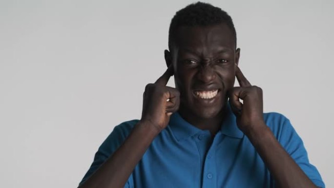 恼怒的非洲裔美国人用手指在情感上遮住耳朵