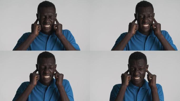 恼怒的非洲裔美国人用手指在情感上遮住耳朵