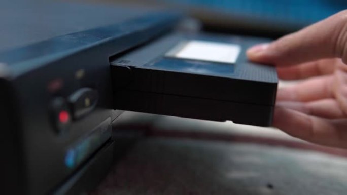 用户在老式录像机上播放VHS录像带。选择性聚焦