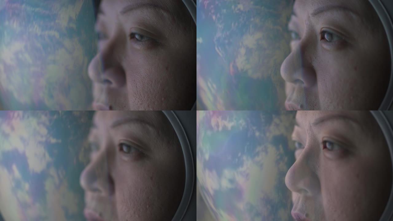 亚洲中国中年女宇航员从太空飞船通过窗户看着地球