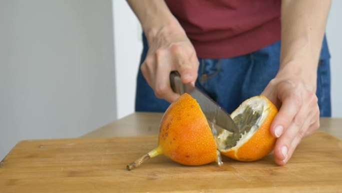 新鲜有机成熟的格兰那迪拉或黄色百香果在木板上切成两半。异国水果，健康饮食理念
