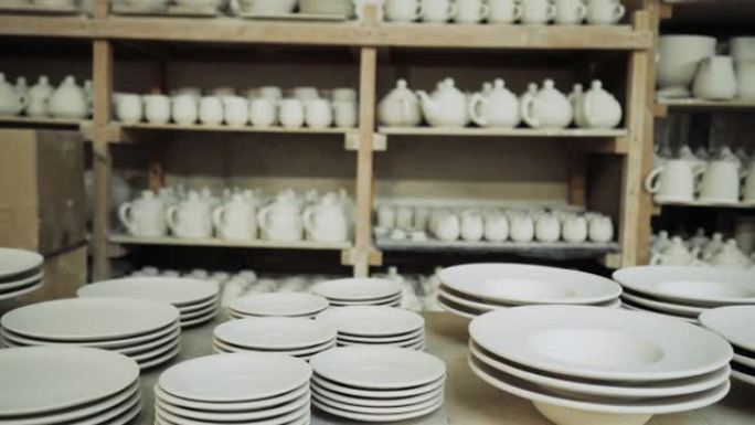 生产车间的货架上摆着白色陶瓷杯和盘子