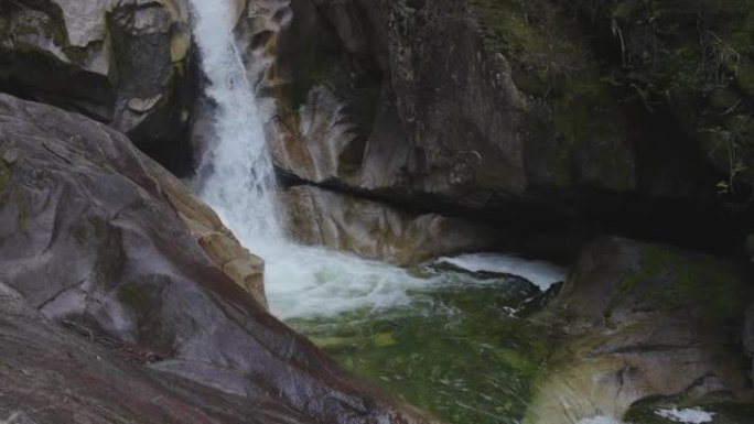 水顺着加拿大山区景观中光滑的岩石峡谷流下。