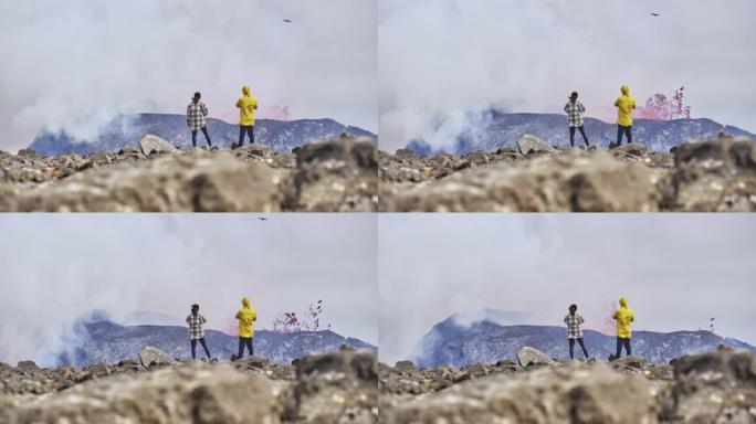 喜欢冒险的游客欣赏火山爆发的景色