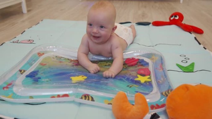 可爱的小男孩在客厅玩儿童充气水气垫，婴儿活动玩水垫水下世界婴儿气垫垫。