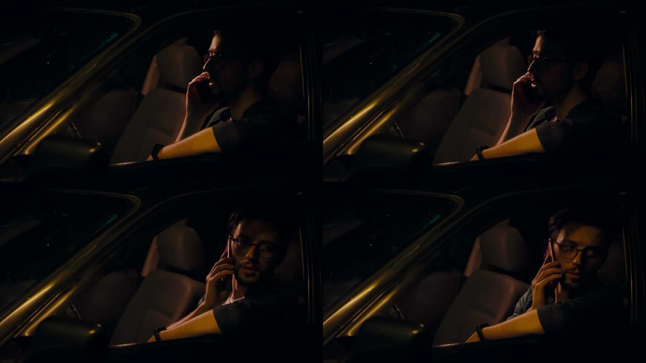 男人晚上坐在车里，打电话。