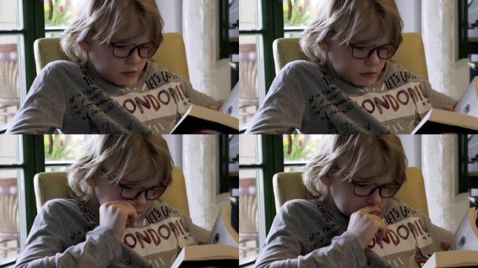 戴着眼镜看书的小男孩。