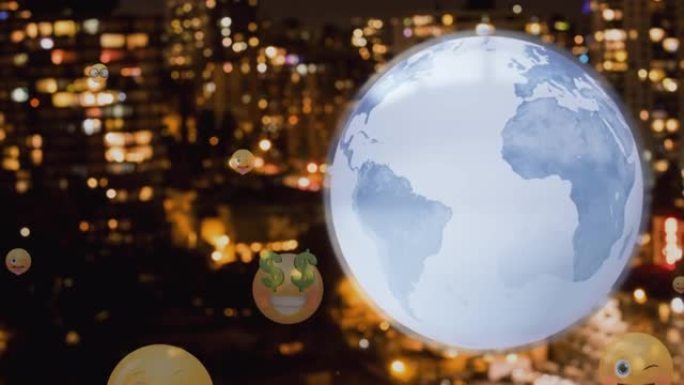 旋转地球仪和多面表情符号图标在夜间漂浮在城市景观的鸟瞰图上