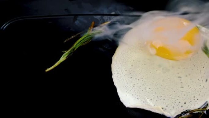 煎锅上的新鲜煎鸡蛋，家用厨房上的油炸迷迭香营养均衡食物。