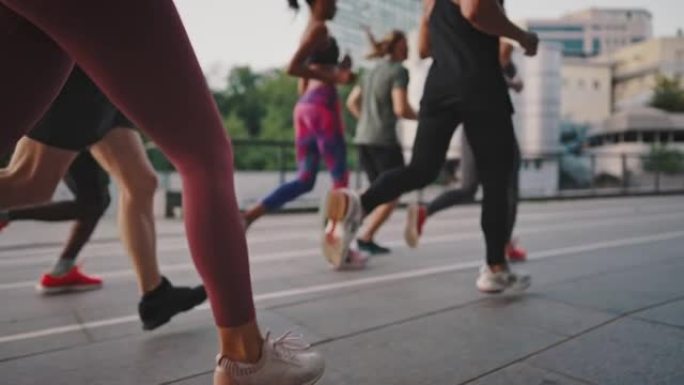 由志同道合的人组成的多种族团队在城市街道上奔跑。穿着运动服和鞋子的人进行集体锻炼。跑步俱乐部