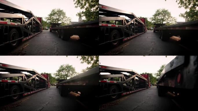 两辆装有卡车的卡车停在停车场。后视图，移动摄像机