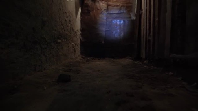在黑暗中照射手电筒。穿过古老的黑暗地下地下室或老房子的壁橱。古老的庄园里有许多门的古老地下通道。阴暗