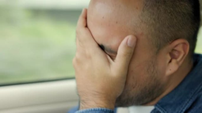 年轻的亚洲男子司机昏昏欲睡。他打了个哈欠，正要睡着。打瞌睡，长时间开车，睡眠不足