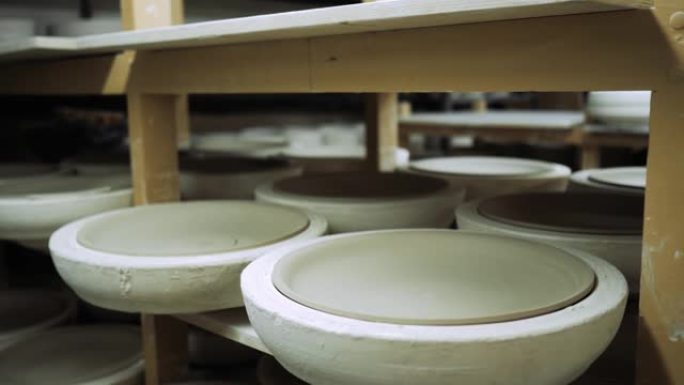陶瓷餐具的模具在生产货架上，陶瓷在其中硬化。