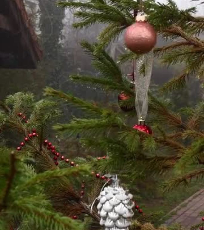 复古圣诞饰品挂在针叶树树枝上，随风摇荡