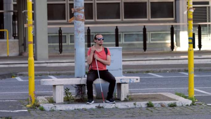 残障人士，残障人士-盲人坐在长凳上等待过马路