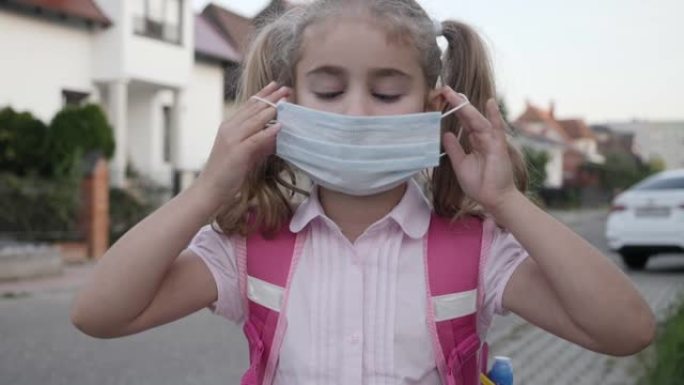 新型冠状病毒肺炎女童戴上保护面具，防止冠状病毒。回到学校。戴着保护面具的孩子的肖像。健康医疗和安全，