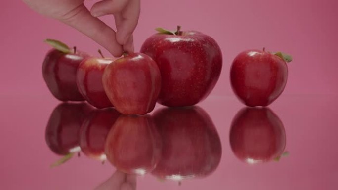 健康美容水果红苹果用一只手触摸健康甜苹果