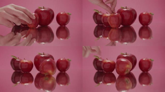 健康美容水果红苹果用一只手触摸健康甜苹果