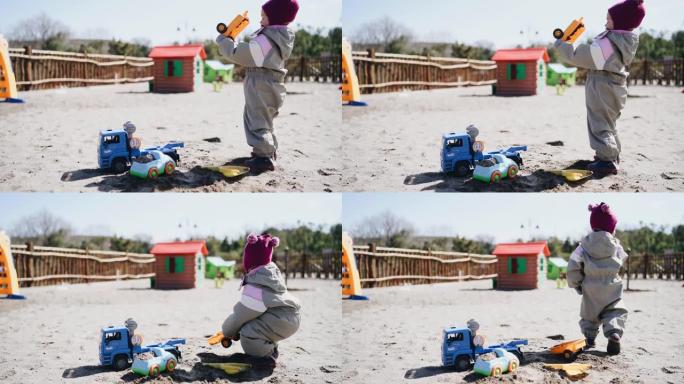 小女孩在操场上从玩具车上倒沙子