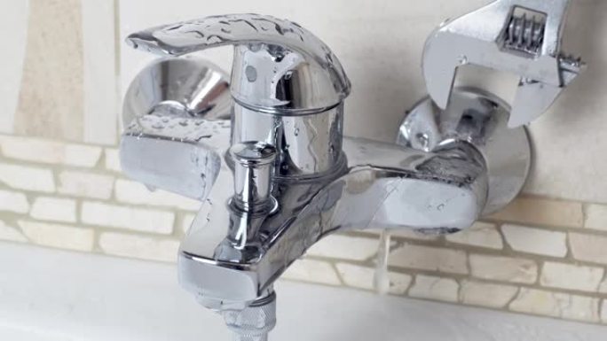 水管工用可调扳手固定漏水水龙头，自制工作屋浴室淋浴保持工作固定漏水修理。