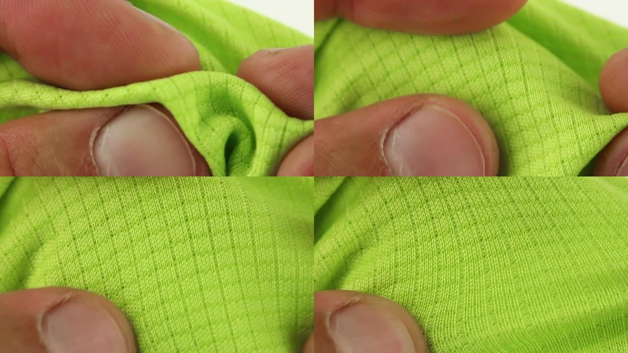 手部测试和拉伸绿色运动透气合成面料，跑步和健身用透气性纺织品，特写宏观视图