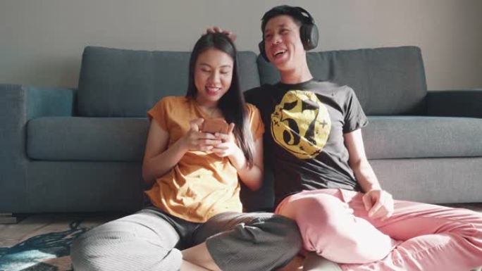 东南亚年轻夫妇在客厅一起听音乐