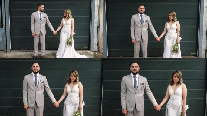 年轻的婚礼夫妇在车库门前摆姿势