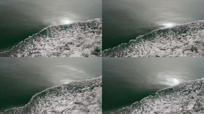 在航行中从船到游艇的慢动作波浪表面的特写镜头。