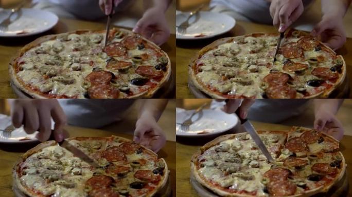 意大利薄薄的意大利辣香肠橄榄披萨一半，蘑菇火腿切成薄片，以供分享