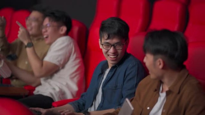 亚洲华裔年轻人观众笑着看电影坐在电影院电影院里欣赏