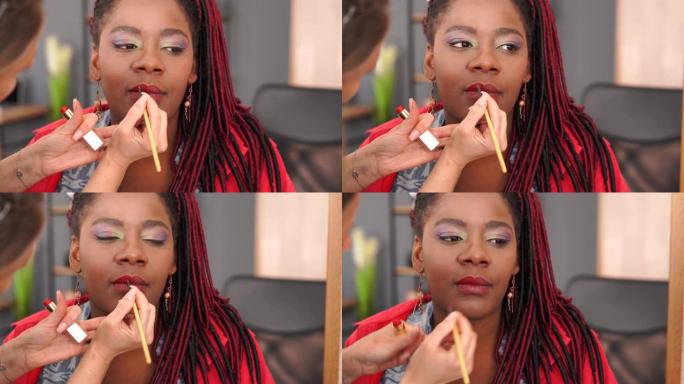 4k视频特写化妆师给一个非洲女孩专业化妆的眼睛戴上眼影
