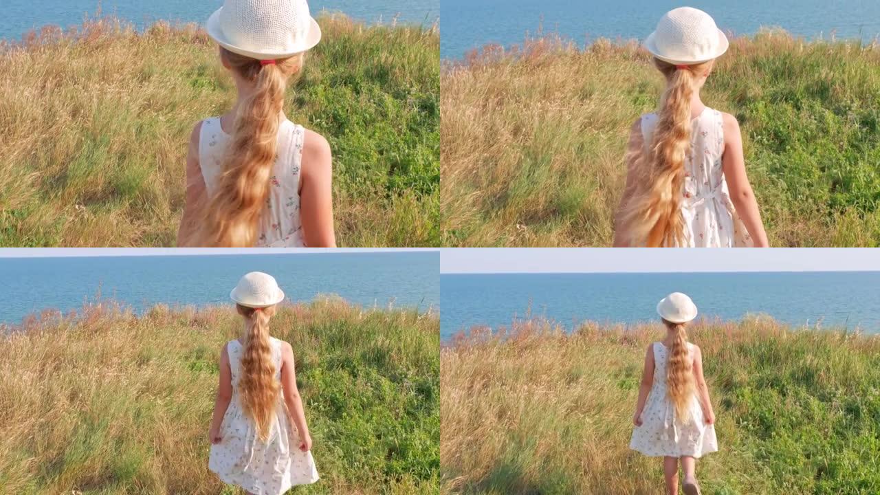 可爱的开朗的小女孩，穿着白色棉质连衣裙，在山丘和海洋景观上清晰的蓝天背景。快乐的微笑的孩子，长长的金
