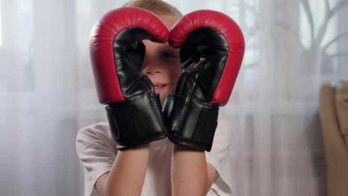 一个戴着拳击手套的小男孩用手做成心形。