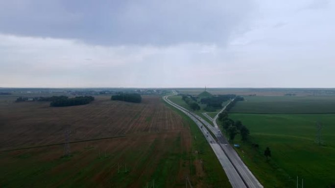 道路和运输的鸟瞰图。人们在高速公路上开车旅行。背景上的白俄罗斯荣耀纪念碑。戏剧性的天空。物流和旅行概