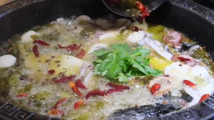 将热腾腾的辣椒油倒入鱼汤和酸菜中。慢动作。