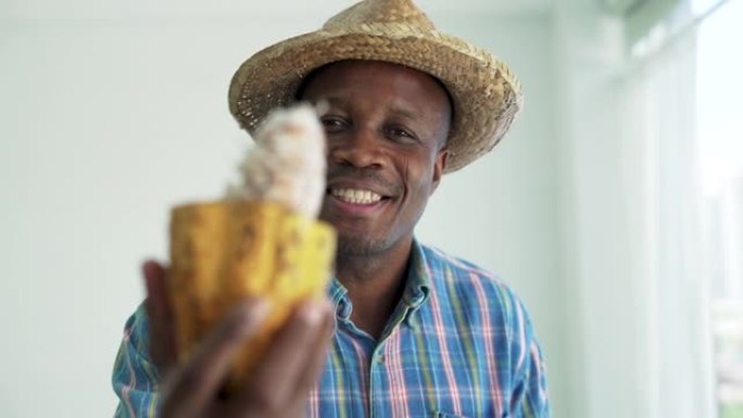 非洲黑人农民在农场拿着成熟的可可果实。