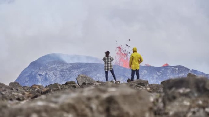 几个旅行者欣赏火山爆发的景观