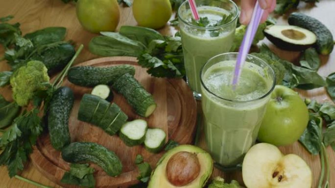 有机鲜榨绿色蔬菜和水果冰沙放入玻璃杯中