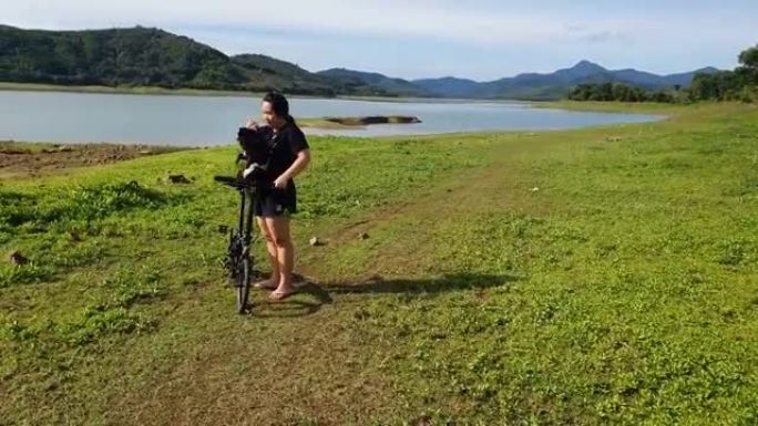 年轻女子夏天在湖和山上旅行机智狗