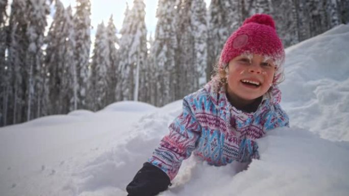 SLO MO女孩躺在雪地里，一边笑，一边向镜头扔雪