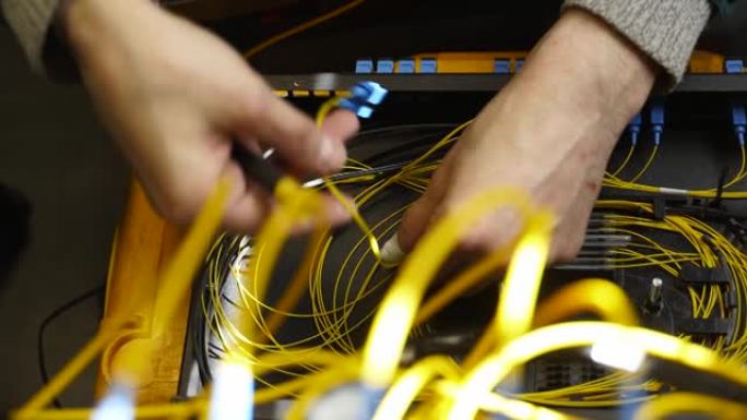 工人在连接盒中连接光线路互联网电线。维修人员焊接光纤。互联网服务提供商工程师在服务器机房工作，负责光