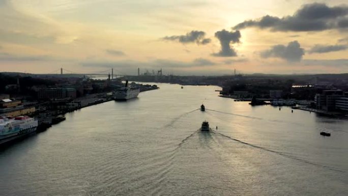 哥德堡空中无人驾驶飞机在日落时在g ö ta ä lv河上航行的船只。