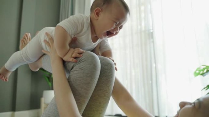 亚洲男婴在妈妈和他玩耍时大笑
